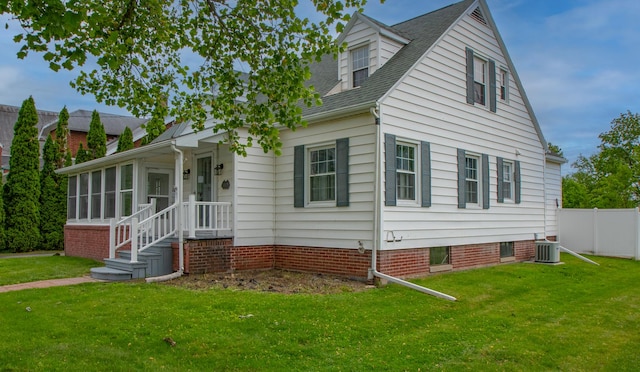 110 N Newton St, Goodland, IN 47948 - view of front facade with cooling unit, a sunroom, and a shingled roof