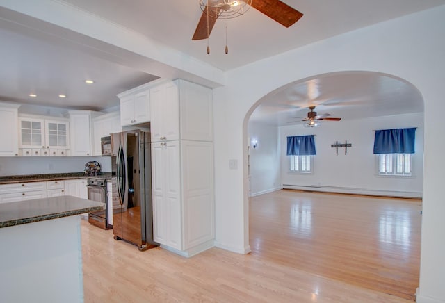 110 N Newton St, Goodland, IN 47948 - kitchen featuring ceiling fan, freestanding refrigerator, arched walkways, black stove, and light wood-style floors