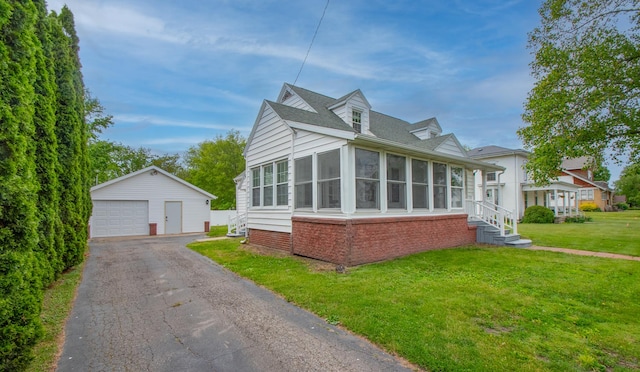 110 N Newton St, Goodland, IN 47948 - view of front facade with an outbuilding, a garage, a front lawn, a sunroom, and brick siding