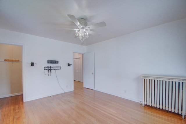 110 N Newton St, Goodland, IN 47948 - unfurnished bedroom featuring radiator heating unit, light wood-style flooring, baseboards, and ceiling fan