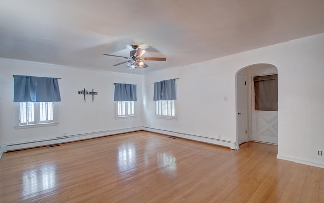 110 N Newton St, Goodland, IN 47948 - unfurnished room featuring arched walkways, a ceiling fan, wood finished floors, baseboard heating, and baseboards