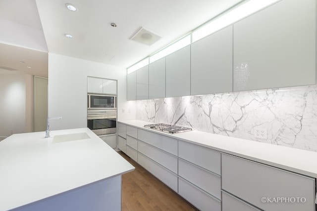 401 N Wabash Ave Unit 39G, Chicago, IL 60611 - kitchen with stainless steel appliances, a sink, modern cabinets, decorative backsplash, and light countertops
