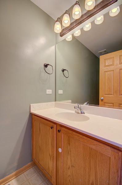 1716 Waters Edge Dr Unit 1716, Minooka, IL 60447 - bathroom featuring vanity, vaulted ceiling, tile patterned floors, and baseboards
