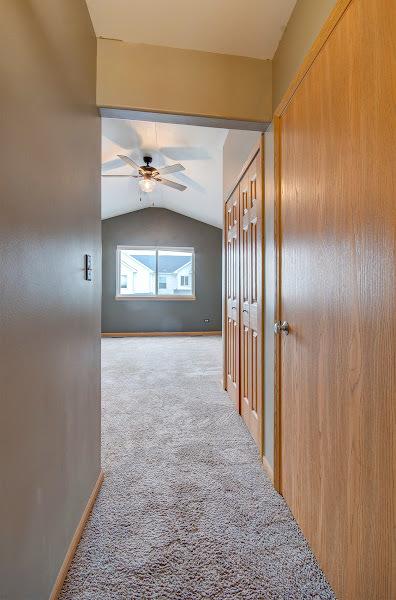 1716 Waters Edge Dr Unit 1716, Minooka, IL 60447 - hall with vaulted ceiling, carpet flooring, and baseboards