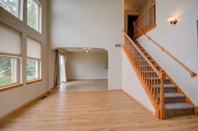 1716 Waters Edge Dr Unit 1716, Minooka, IL 60447 - stairway with arched walkways, a towering ceiling, plenty of natural light, and wood finished floors