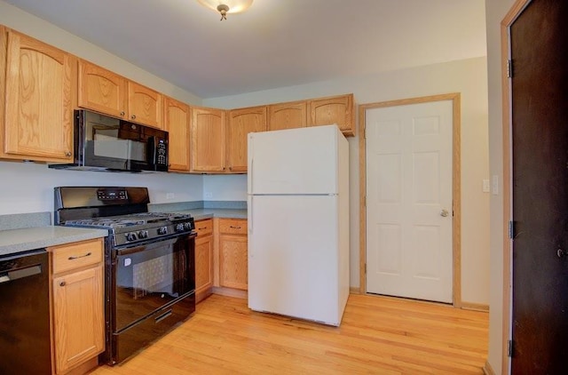 1716 Waters Edge Dr Unit 1716, Minooka, IL 60447 - kitchen featuring black appliances, light wood-style floors, light countertops, and light brown cabinetry