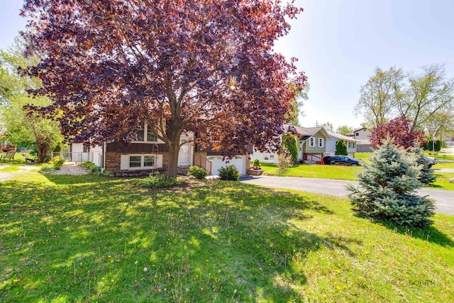 14 Wander Way, Lake In The Hills, IL 60156 - view of property hidden behind natural elements featuring driveway, a front lawn, a residential view, and brick siding