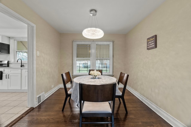 9026 S Colfax Ave, Chicago, IL 60617 - dining area with a chandelier, baseboards, and dark wood finished floors