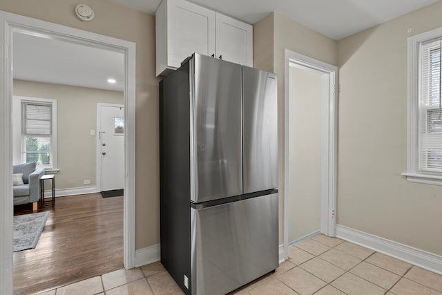 9026 S Colfax Ave, Chicago, IL 60617 - kitchen with freestanding refrigerator, white cabinetry, baseboards, and light tile patterned floors