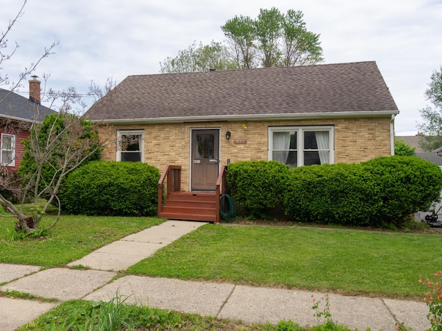 431 Griswold St, Elgin, IL 60123 - view of front of home with roof with shingles, a front lawn, and brick siding