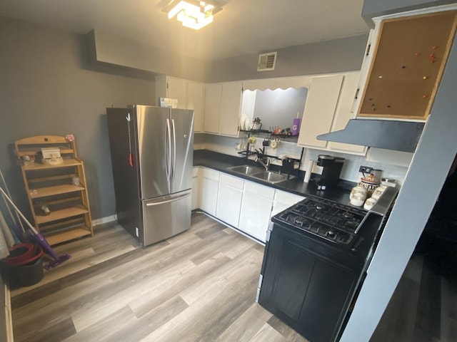 10715 S Keating Ave Unit 1C, Oak Lawn, IL 60453 - kitchen featuring freestanding refrigerator, a sink, black gas range oven, under cabinet range hood, and dark countertops