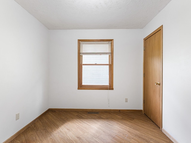 119 SE Brandywine Dr, Poplar Grove, IL 61065 - spare room featuring light wood-style floors, a textured ceiling, and baseboards