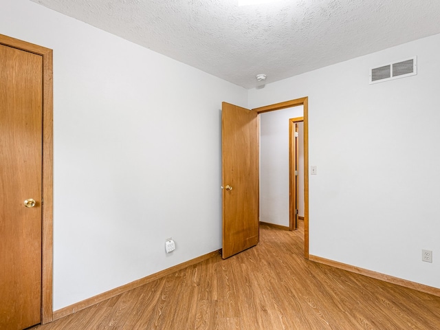 119 SE Brandywine Dr, Poplar Grove, IL 61065 - empty room with baseboards, light wood-style flooring, and a textured ceiling