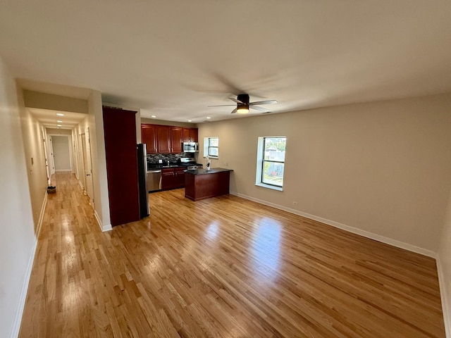 6324 S Kimbark Ave Unit 404, Chicago, IL 60637 - kitchen with light wood-style flooring, appliances with stainless steel finishes, a ceiling fan, backsplash, and dark countertops