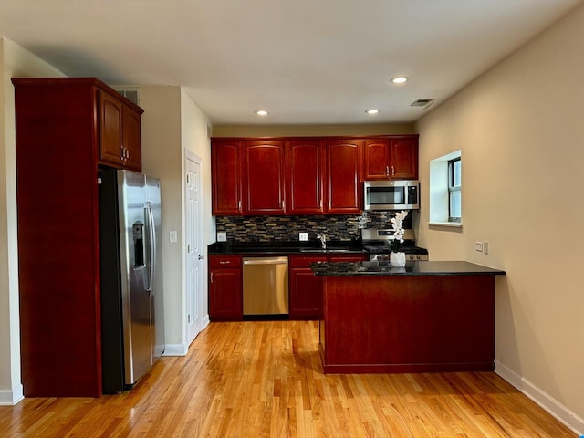 6324 S Kimbark Ave Unit 404, Chicago, IL 60637 - kitchen with stainless steel appliances, reddish brown cabinets, dark countertops, tasteful backsplash, and light wood-style floors