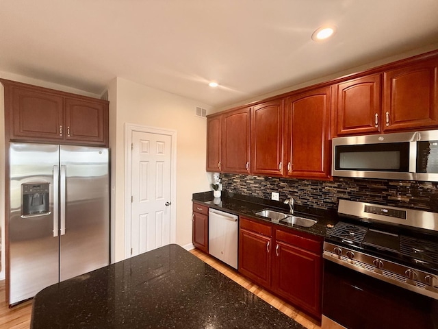 6324 S Kimbark Ave Unit 404, Chicago, IL 60637 - kitchen featuring stainless steel appliances, a sink, tasteful backsplash, light wood-style flooring, and dark stone counters