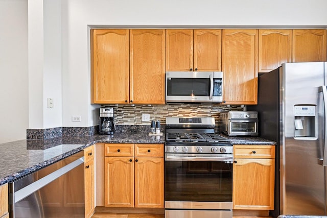 7511 Brown Ave Unit N, Forest Park, IL 60130 - kitchen with stainless steel appliances, dark stone counters, and decorative backsplash