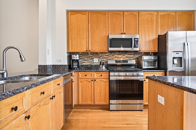 7511 Brown Ave Unit N, Forest Park, IL 60130 - kitchen with stainless steel appliances, dark stone countertops, light wood finished floors, backsplash, and brown cabinetry