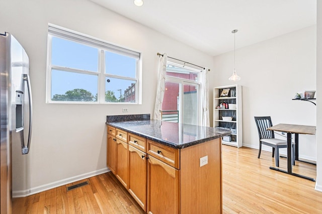 7511 Brown Ave Unit N, Forest Park, IL 60130 - kitchen with stainless steel refrigerator with ice dispenser, a peninsula, light wood-style flooring, dark stone counters, and hanging light fixtures