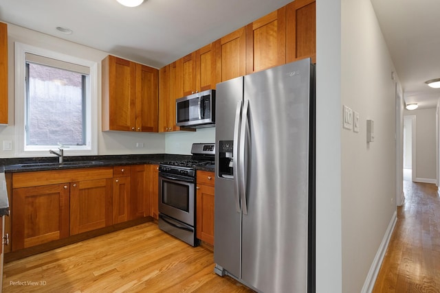 25 E 26th St Unit 4, Chicago, IL 60616 - kitchen featuring appliances with stainless steel finishes, a sink, light wood-type flooring, and brown cabinetry