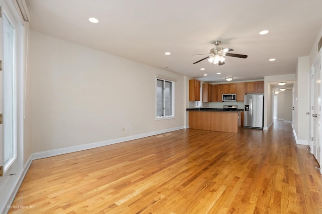 25 E 26th St Unit 4, Chicago, IL 60616 - kitchen with stainless steel appliances, brown cabinets, dark countertops, ceiling fan, and light wood finished floors