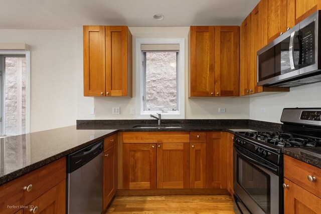 25 E 26th St Unit 4, Chicago, IL 60616 - kitchen with appliances with stainless steel finishes, a sink, dark stone countertops, and brown cabinets