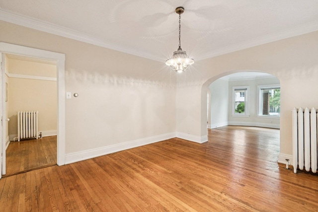 217 S Oak Park Ave, Oak Park, IL 60302 - spare room with radiator, arched walkways, a chandelier, light wood-style flooring, and crown molding
