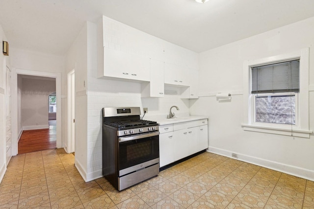 217 S Oak Park Ave, Oak Park, IL 60302 - kitchen with stainless steel gas range, white cabinetry, light countertops, and light tile patterned floors
