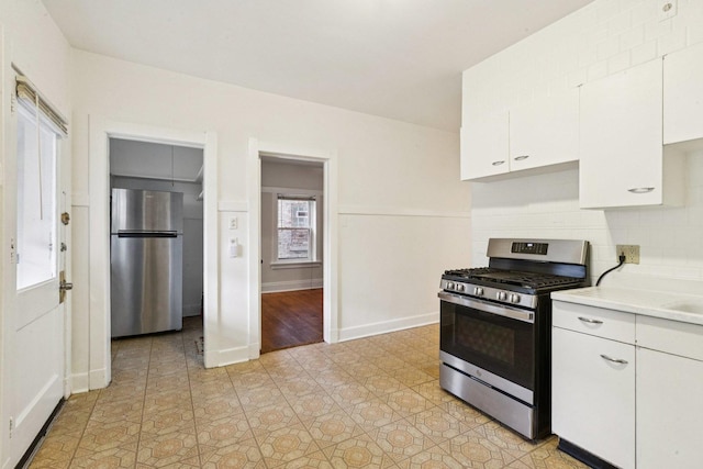 217 S Oak Park Ave, Oak Park, IL 60302 - kitchen featuring appliances with stainless steel finishes, white cabinetry, light countertops, light tile patterned floors, and tasteful backsplash