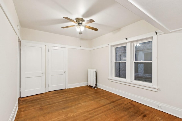 217 S Oak Park Ave, Oak Park, IL 60302 - unfurnished bedroom featuring radiator, wood finished floors, and ceiling fan