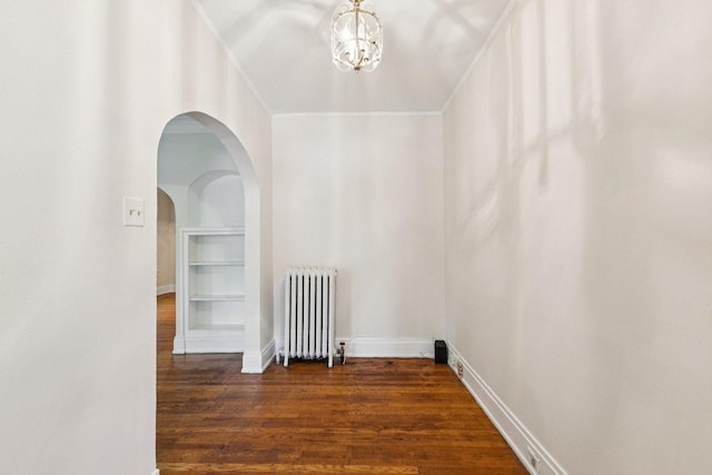 217 S Oak Park Ave, Oak Park, IL 60302 - empty room with radiator heating unit, dark wood-type flooring, a chandelier, and arched walkways