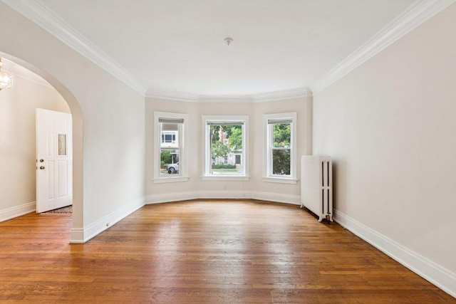 217 S Oak Park Ave, Oak Park, IL 60302 - spare room with radiator, arched walkways, wood-type flooring, and crown molding