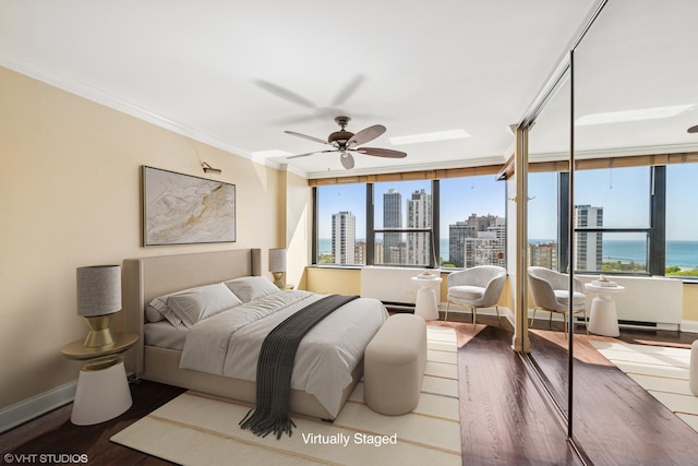 1560 N Sandburg Ter Unit 2202, Chicago, IL 60610 - bedroom with wood finished floors, ornamental molding, a view of skyline, and multiple windows