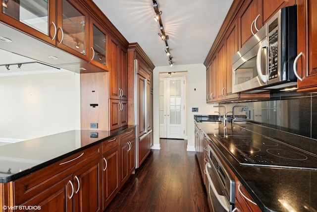 1560 N Sandburg Ter Unit 2202, Chicago, IL 60610 - kitchen with appliances with stainless steel finishes, a sink, dark wood-type flooring, rail lighting, and baseboards