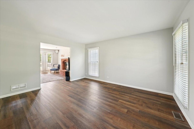 616 Meadowview Dr, West Chicago, IL 60185 - unfurnished living room featuring dark wood-type flooring, baseboards, and a brick fireplace