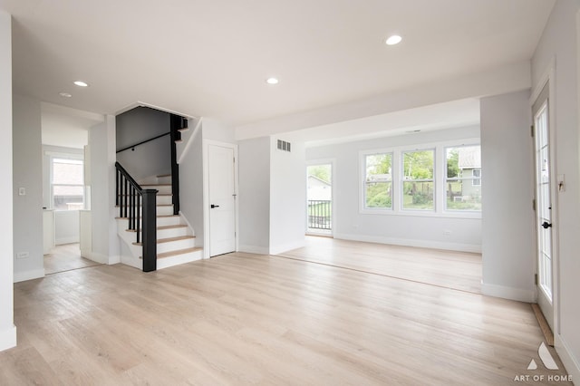 26415 W Beach St, Antioch, IL 60002 - unfurnished living room featuring healthy amount of natural light, light wood finished floors, stairway, baseboards, and recessed lighting