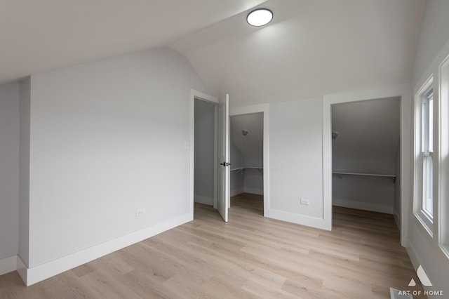 26415 W Beach St, Antioch, IL 60002 - unfurnished bedroom featuring a walk in closet, vaulted ceiling, light wood-style floors, a closet, and baseboards