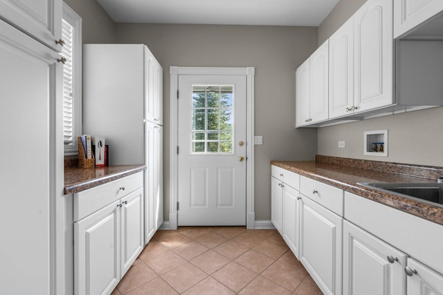 6312 Kingsbridge Dr, Cary, IL 60013 - laundry room featuring washer hookup, light tile patterned flooring, and cabinet space