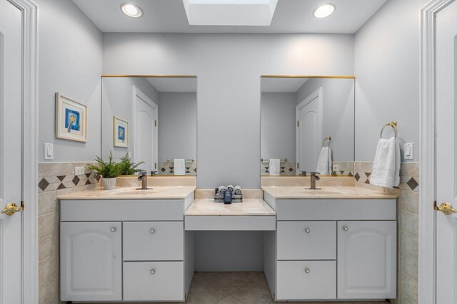 6312 Kingsbridge Dr, Cary, IL 60013 - bathroom featuring tile walls, a skylight, vanity, tile patterned flooring, and wainscoting