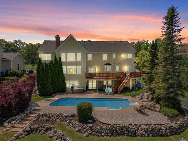 6312 Kingsbridge Dr, Cary, IL 60013 - back of property at dusk with stairs, a wooden deck, a chimney, a patio area, and an outdoor pool