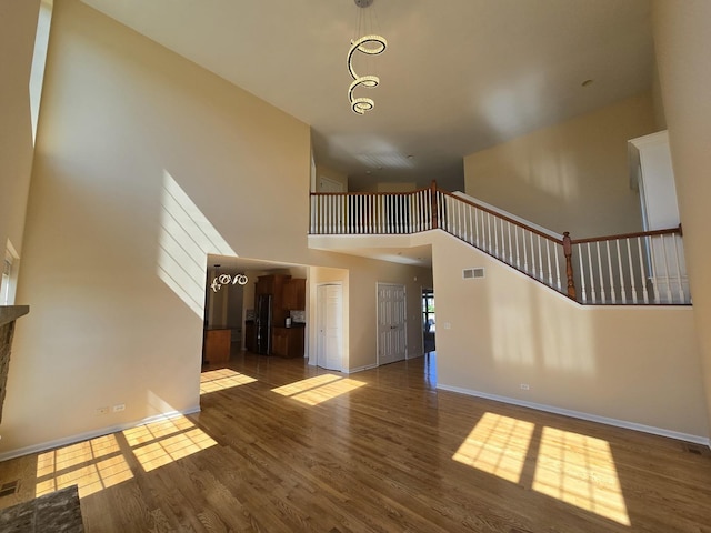 2333 Roaring Creek Dr, Aurora, IL 60503 - unfurnished living room featuring a towering ceiling, wood finished floors, and stairs