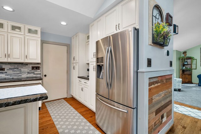 26138 Oak Ridge Ct, Channahon, IL 60410 - kitchen featuring stainless steel fridge, dark countertops, tasteful backsplash, light wood-type flooring, and vaulted ceiling