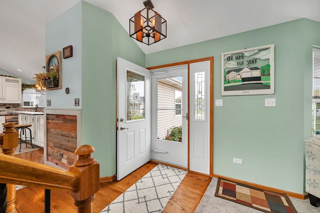 26138 Oak Ridge Ct, Channahon, IL 60410 - entryway featuring vaulted ceiling, a chandelier, healthy amount of natural light, and baseboards