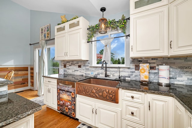 26138 Oak Ridge Ct, Channahon, IL 60410 - kitchen featuring vaulted ceiling, a sink, backsplash, dark stone countertops, and light wood-style floors