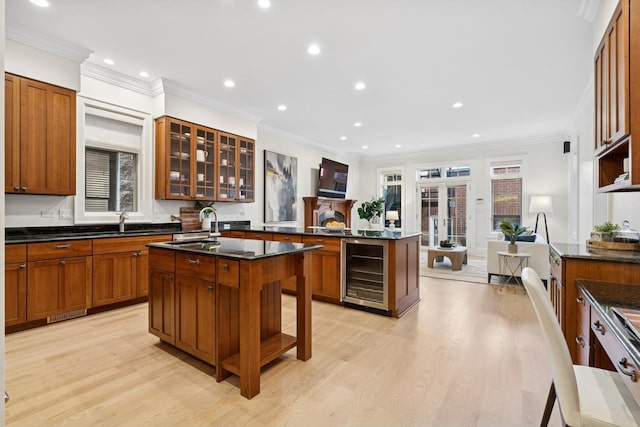 3823 N Wayne Ave, Chicago, IL 60613 - kitchen featuring beverage cooler, light wood finished floors, ornamental molding, brown cabinets, and glass insert cabinets