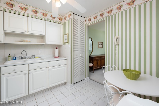 6660 S Brainard Ave Unit 201, Countryside, IL 60525 - kitchen featuring a sink, wallpapered walls, light countertops, white cabinetry, and decorative backsplash