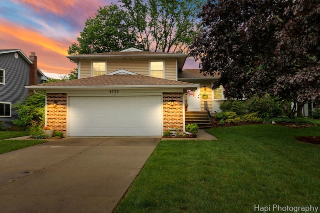4125 Victoria Dr, Hoffman Estates, IL 60192 - tri-level home featuring a front yard, brick siding, driveway, and an attached garage