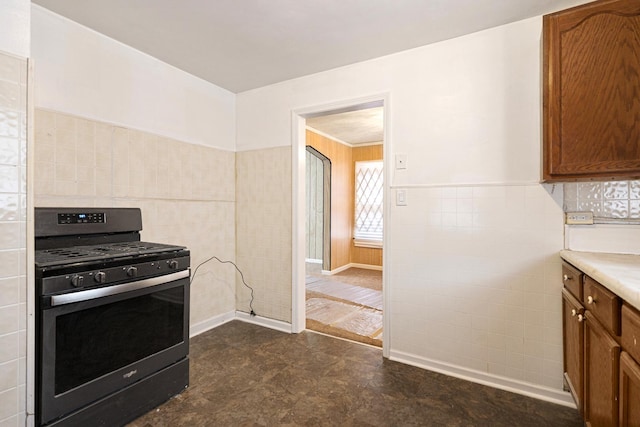 8505 S Seeley Ave, Chicago, IL 60620 - kitchen featuring stainless steel gas stove, tile walls, brown cabinetry, light countertops, and dark floors