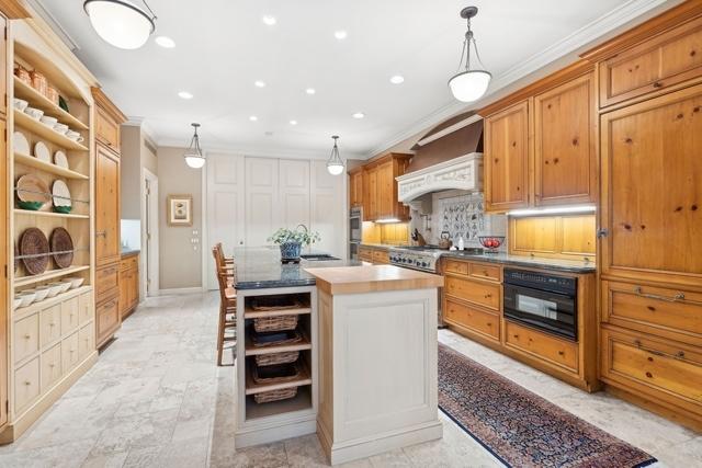 199 E Lake Shore Dr Unit 3, Chicago, IL 60611 - kitchen with open shelves, ornamental molding, a kitchen island with sink, recessed lighting, and decorative light fixtures