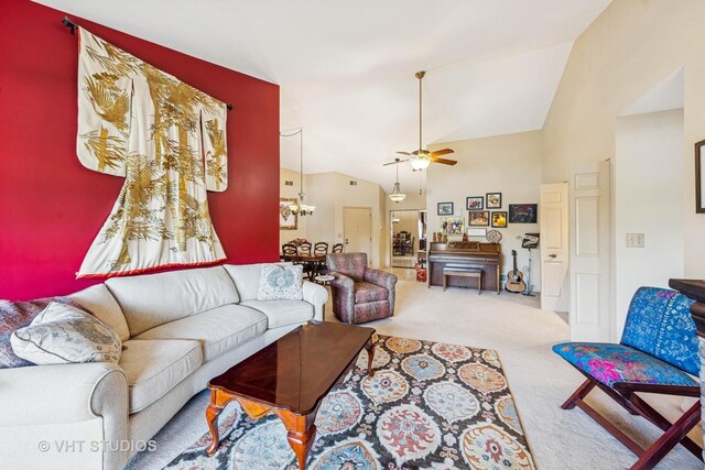 living room featuring carpet, a ceiling fan, lofted ceiling, and a chandelier